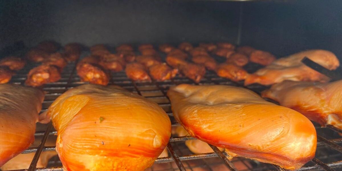 Gerookte kipfilet in plakjes op een plank