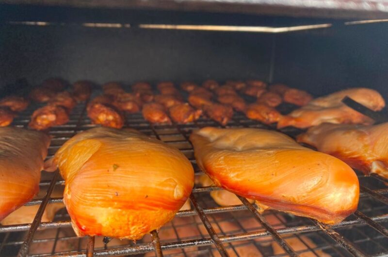Gerookte kipfilet in plakjes op een plank